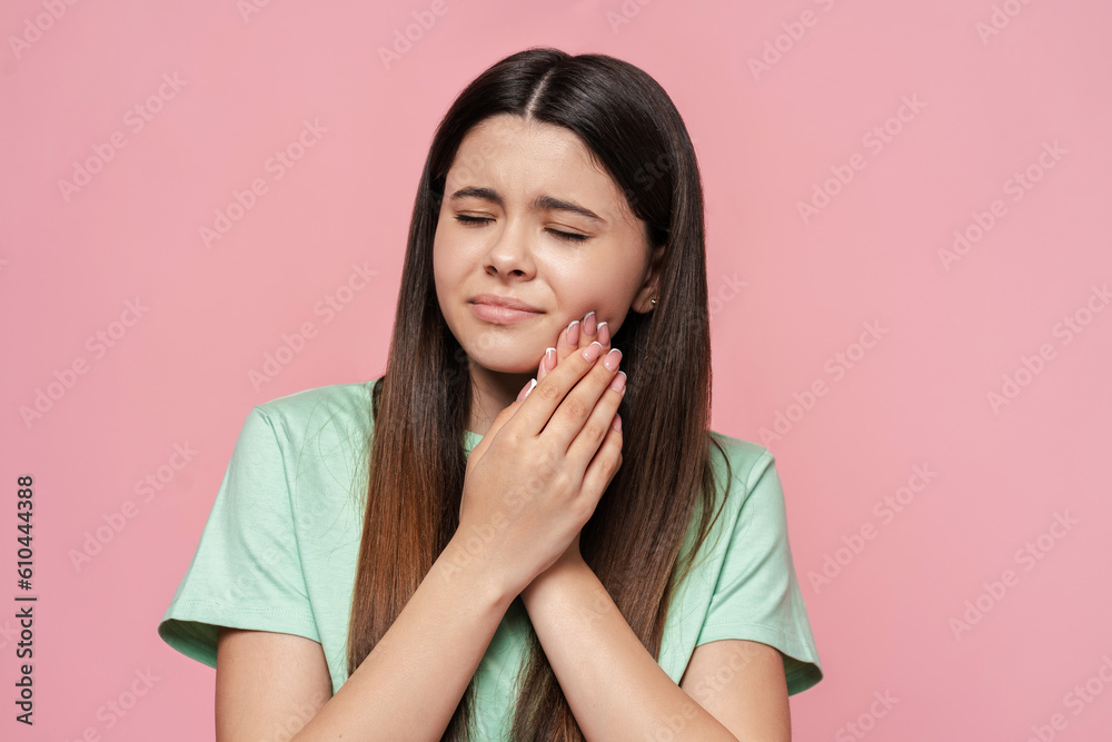 Portrait of sad teenage girl touching cheek, toothache isolated on pink background, dental care Portrait of sad teenage girl touching cheek, toothache isolated on pink background, dental care