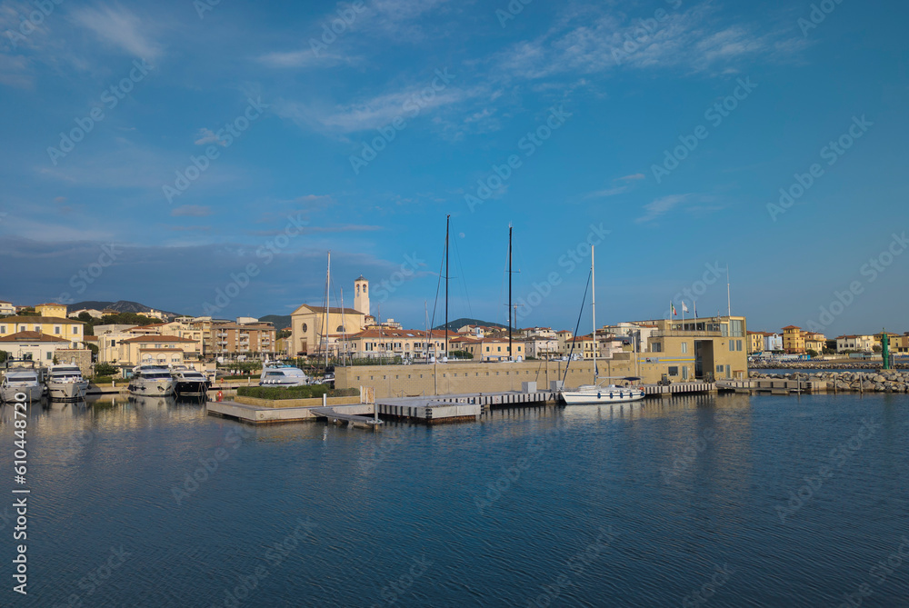 Panorama of the city of San Vincenzo, seen from the sea, with the marina and the church. Blue sky and clouds. Livorno, Tuscany, Italy