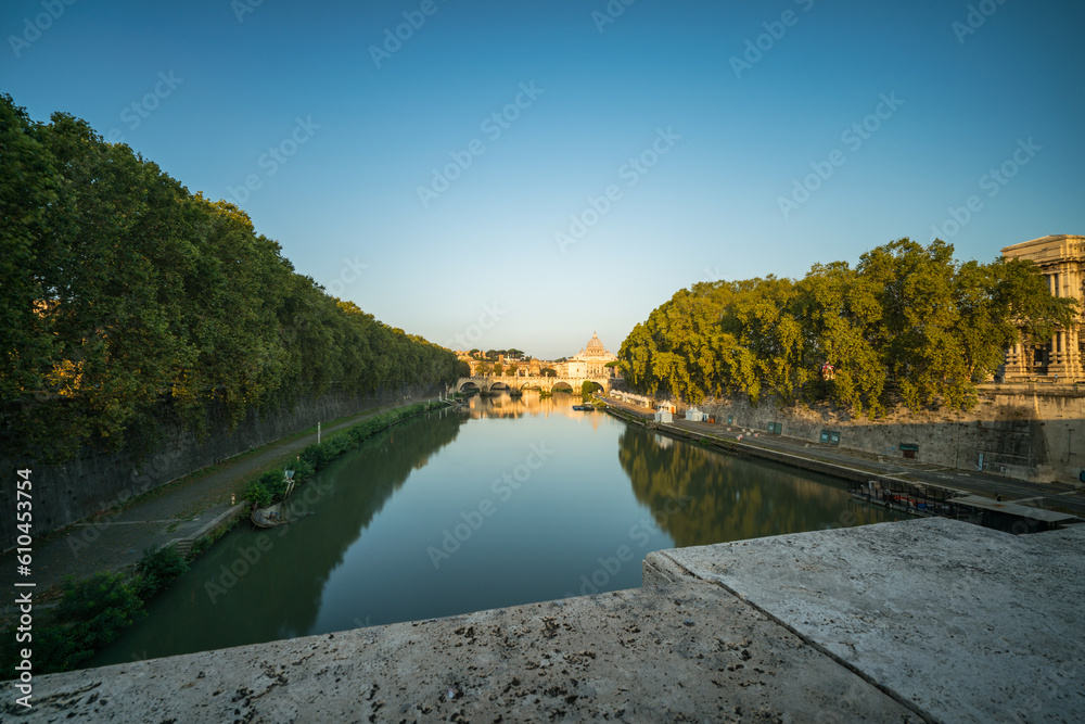 St. Peter's basilica and St. Angelo bridge seen across Tiber river canal in Rome. Italy
