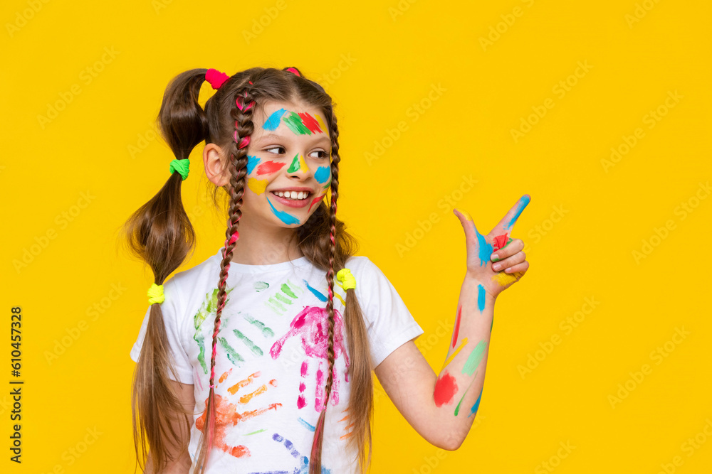 A little girl with bright colors painted, a little girl is fond of drawing, A child with paints on a yellow isolated background. Children's leisure, a schoolgirl at a drawing course. A little girl with bright colors painted, a little girl is fond of drawing, A child with paints on a yellow isolated background. Children's leisure, a schoolgirl at a drawing course.