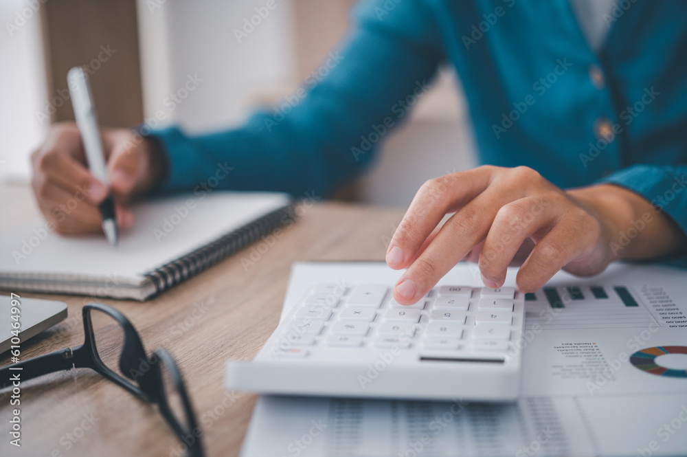 close up The business person is sitting on a calculator with a graph in the office of finance accounting concept close up The business person is sitting on a calculator with a graph in the office of finance accounting concept