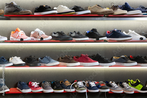 A lot of casual men shoes on shelves in shoe store