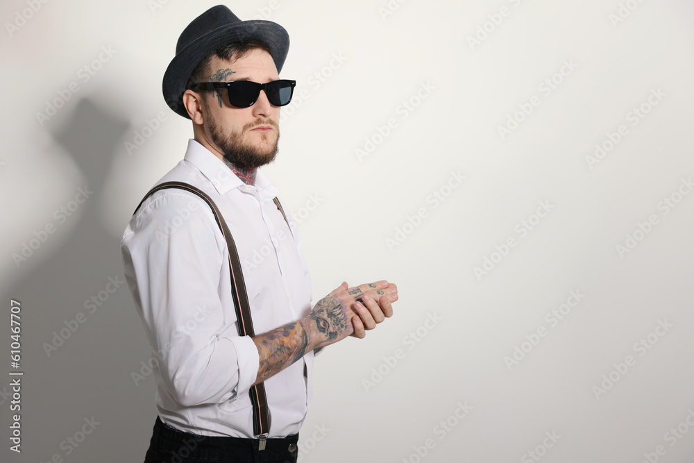 Handsome hipster man wearing stylish sunglasses on light grey background. Space for text Handsome hipster man wearing stylish sunglasses on light grey background. Space for text