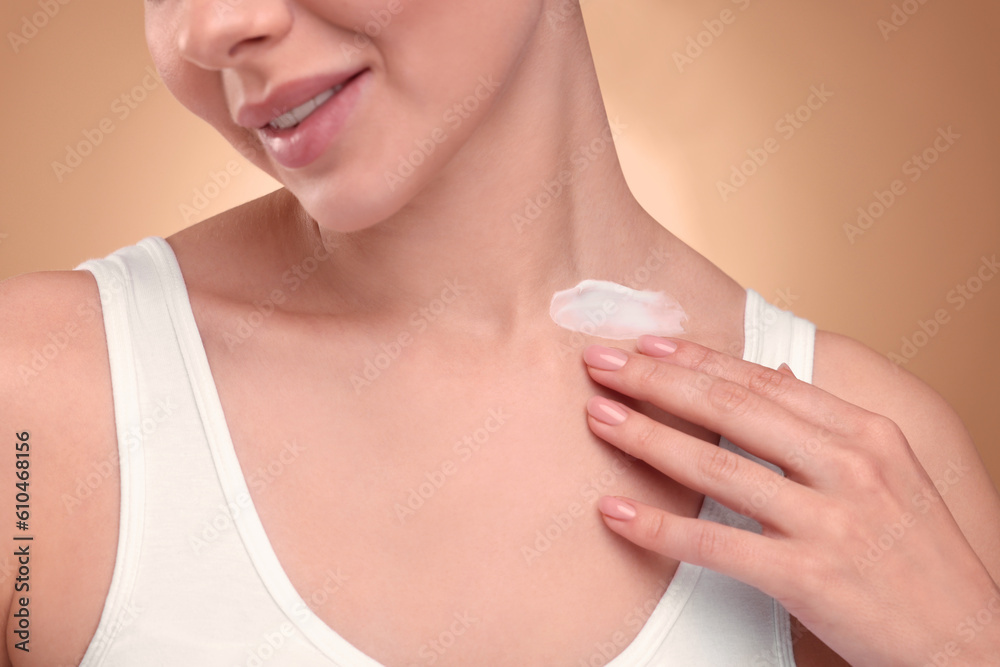 Woman with smear of body cream on her neck against light brown background, closeup Woman with smear of body cream on her neck against light brown background, closeup