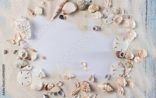 Card, sand and seashells on blue vintage wooden planks, frame for summer advertisement 