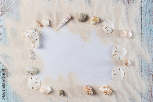 Card, sand and seashells on blue vintge wooden planks, frame for summer advertisement	 photo