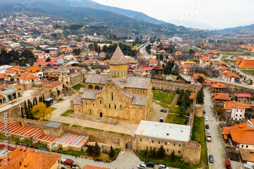 Picturesque aerial view of old Georgian city of Mtskheta surrounded by Caucasus mountains overlooking Orthodox Svetitskhoveli Cathedral in springtime