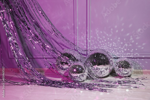 Shiny disco balls and foil fringe curtain indoors, color toned photo