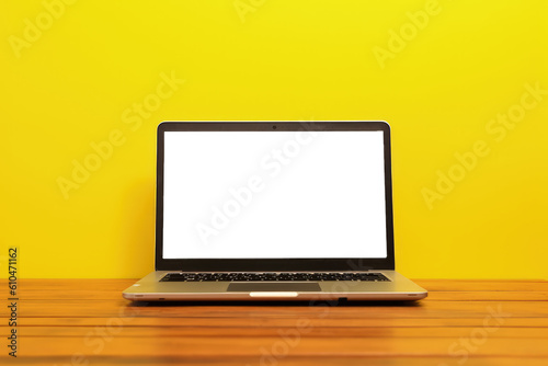 Laptop with transparent screen on top of wooden table and yellow background, Generative AI