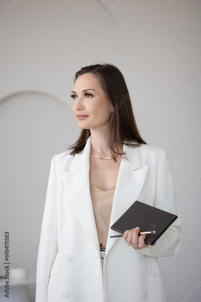Fashion and beauty, stylish makeup artist in a white jacket with makeup brushes in her hands, business portrait of a makeup artist stylist or director of a beauty studio Fashion and beauty, stylish makeup artist in a white jacket with makeup brushes in her hands, business portrait of a makeup artist stylist or director of a beauty studio