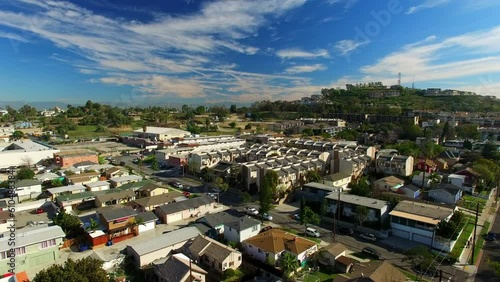 Aerial Panning Shot Of Houses By Streets In Suburb Against Blue Sky, Drone Flying Forward Over Neighborhood On Sunny Day - Long Beach, California