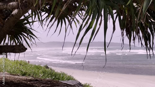 Vertical pan of beach scene on misty day. Woman walking in distance