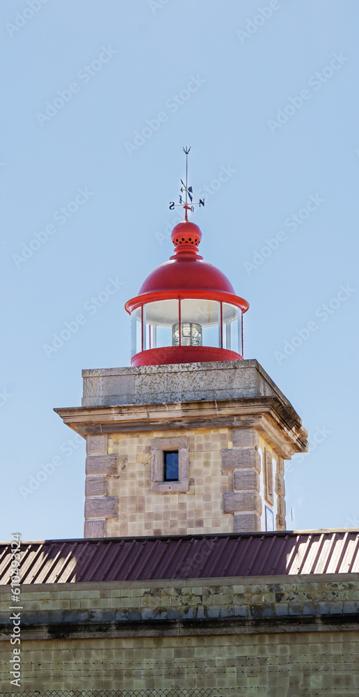 Stone lighthouse with a red top by the ocean Stone lighthouse with a red top by the ocean