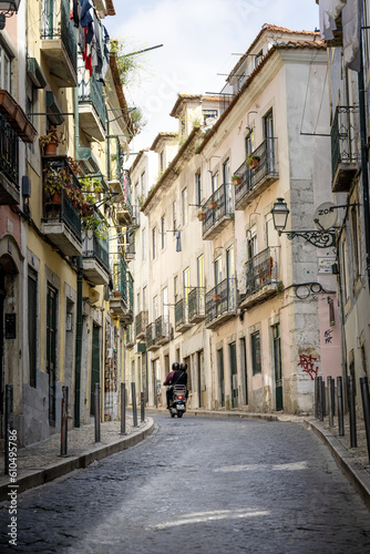 Fototapeta Naklejka Na Ścianę i Meble -  Motorcycle driving down a cobblestone street in Europe