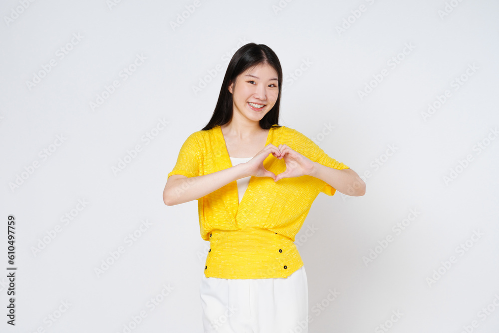 Smilling woman doing a heart shaped gesture with her fingers isolated on white background. Smilling woman doing a heart shaped gesture with her fingers isolated on white background.