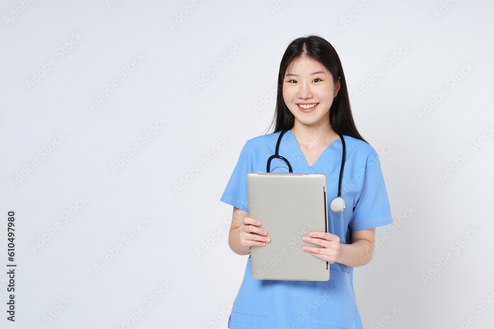 Smiling woman doctor holding laptop and stethoscope isolated on white background. Smiling woman doctor holding laptop and stethoscope isolated on white background.