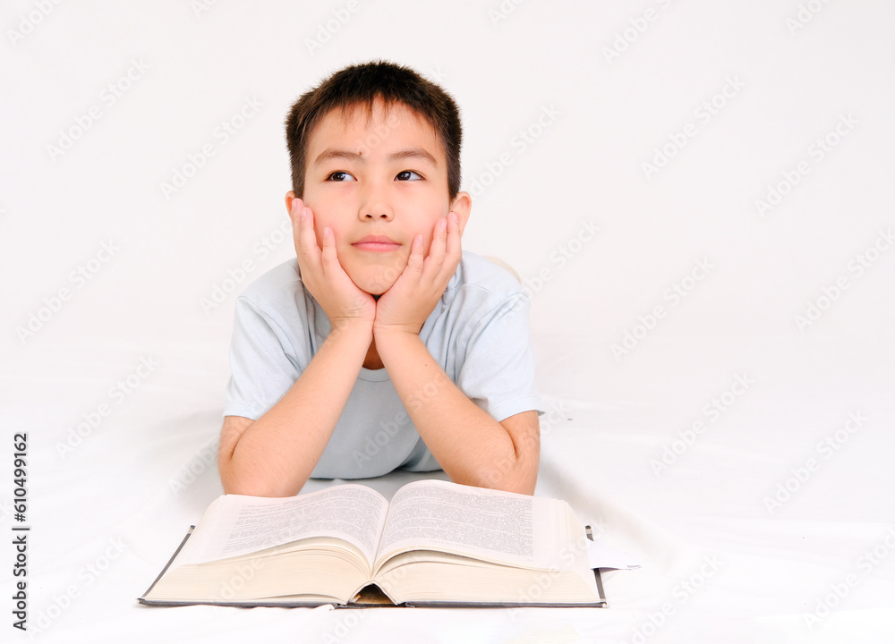 A thinking or daydreaming boy doing homework with glasses, a notebook and a pencil, reading a book highlighted on a white background A thinking or daydreaming boy doing homework with glasses, a notebook and a pencil, reading a book highlighted on a white background