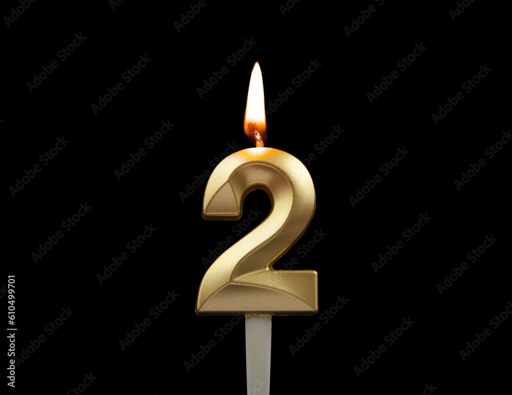 Burning gold birthday candle isolated on black background. Number 2. Burning gold birthday candle isolated on black background. Number 2.