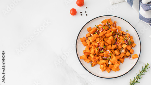 Baked sweet potato slices in a plate on the table. Healthy eating. Vegan dish. Copy space