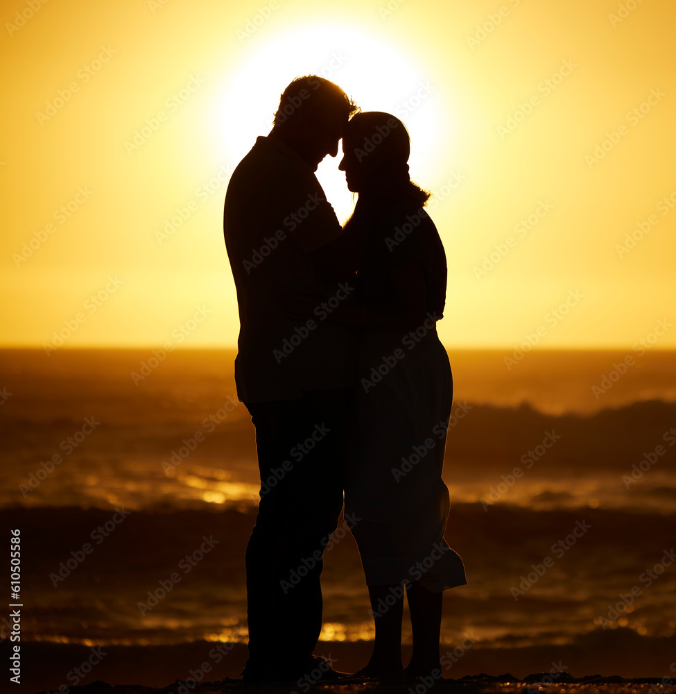 Silhouette, couple and love on a beach at sunset for vacation or holiday outdoor. Romantic man and woman hug in nature with creative sky, space and ocean for care, shadow art and travel or freedom