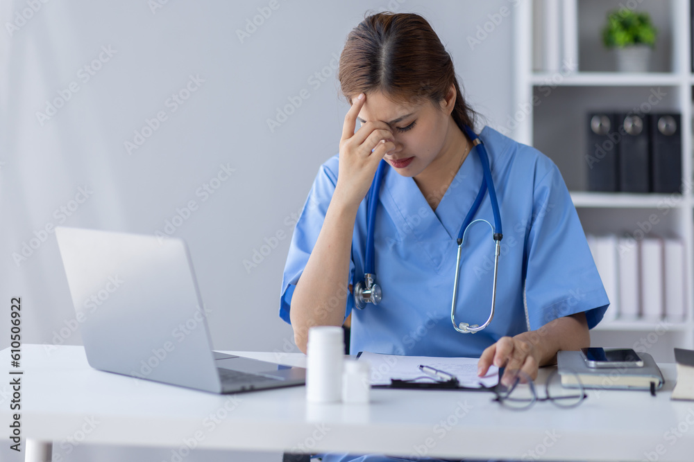 Happy doctor Portrait of young asian woman nurse or doctor smiling using a laptop writing content at consultation Happy doctor Portrait of young asian woman nurse or doctor smiling using a laptop writing content at consultation