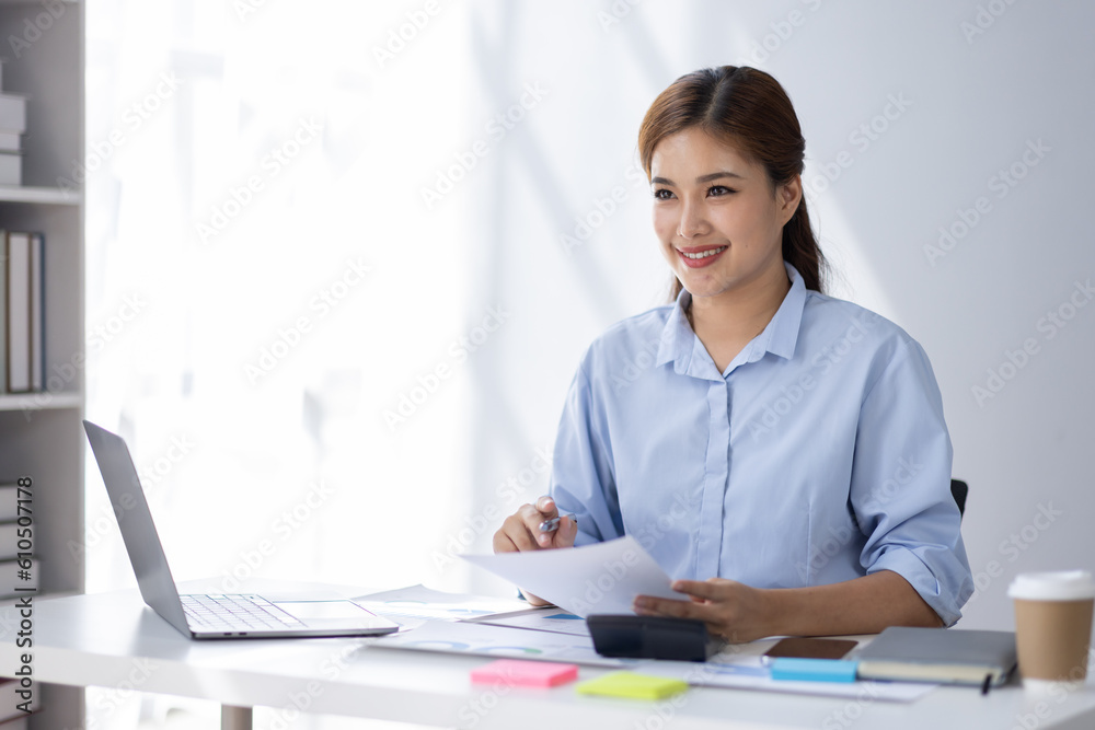 Asian Businesswoman Using laptop computer and working at office with calculator document on desk, doing planning analyzing the financial report, business plan investment, finance analysis concept.
Asian Businesswoman Using laptop computer and working at office with calculator document on desk, doing planning analyzing the financial report, business plan investment, finance analysis concept.