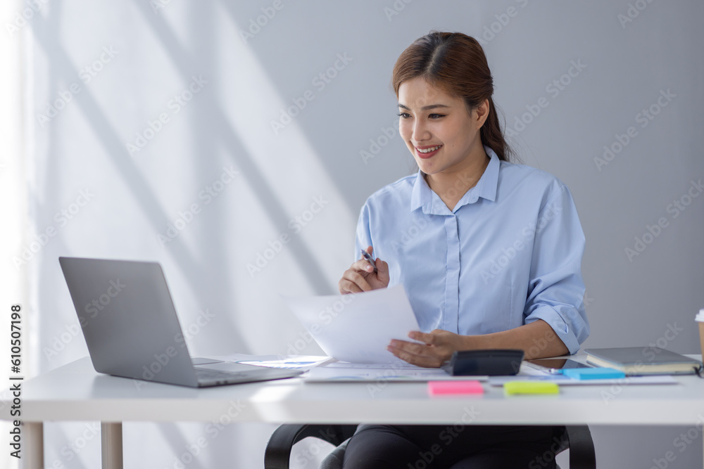 Asian Businesswoman Using laptop computer and working at office with calculator document on desk, doing planning analyzing the financial report, business plan investment, finance analysis concept.
Asian Businesswoman Using laptop computer and working at office with calculator document on desk, doing planning analyzing the financial report, business plan investment, finance analysis concept.