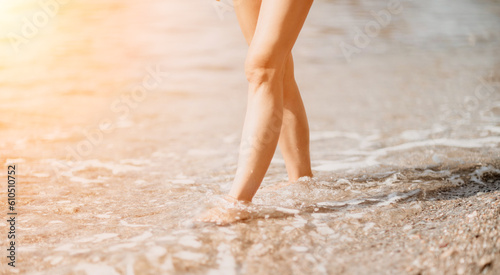 A woman walks along the beach, legs close-up. Barefoot woman sta