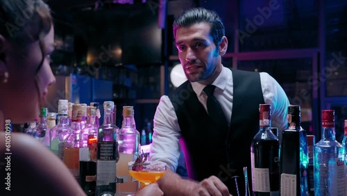 Bartender man sending a cocktail to client on the bar counter in the night party