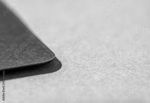 Photo of business card. Template for branding identity. Blank card. Black on grey, place for text. Close up.