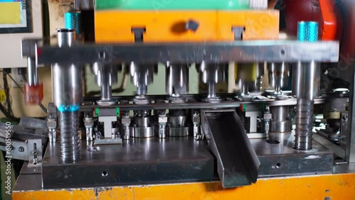 Close up of a punch press forming metal parts in a production line photo