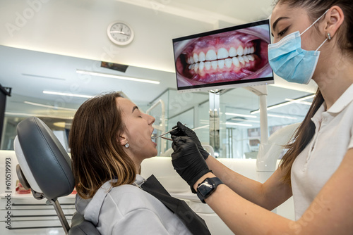 girl dentist examines the teeth of her girl patient during an appointment at a dental clinic.