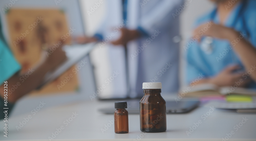 medical team having a meeting with doctors in white lab coats and surgical scrubs seated at a table discussing a patients records,success medical health care, Medicine doctor's working concept