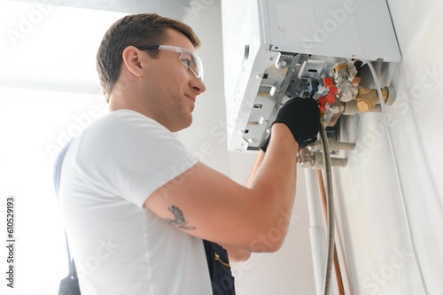 Professional boiler service: qualified technician checking a natural gas boiler at home photo