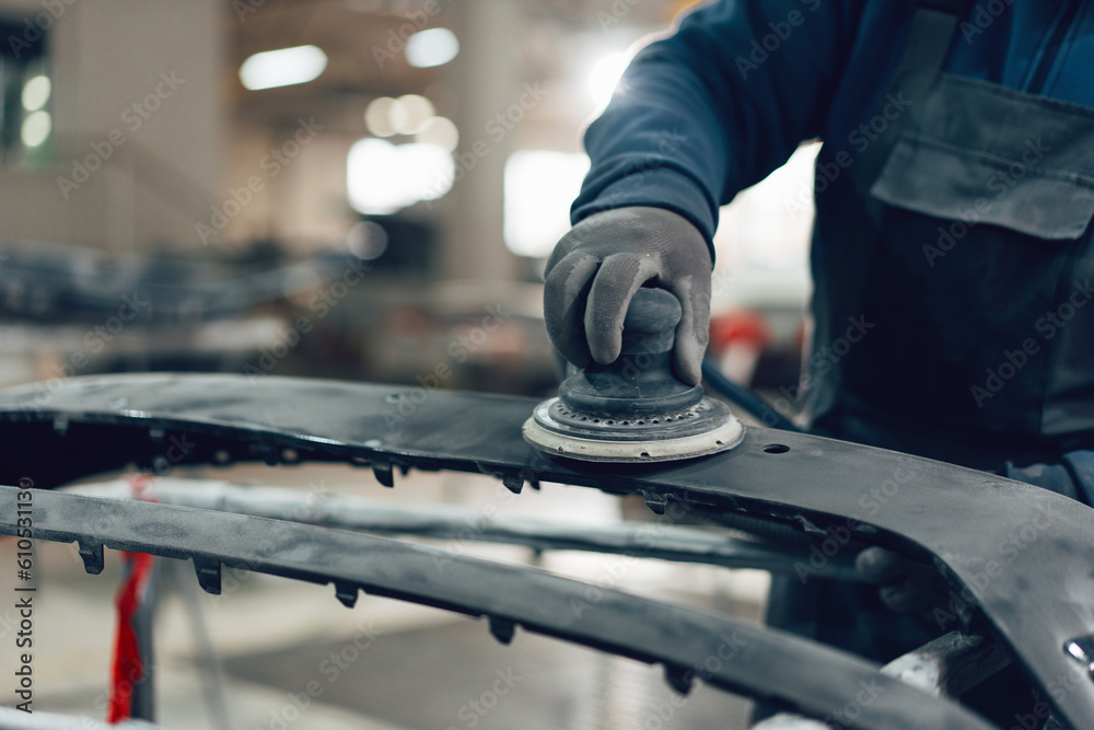 Auto mechanic straightening car body in car service station Auto mechanic straightening car body in car service station