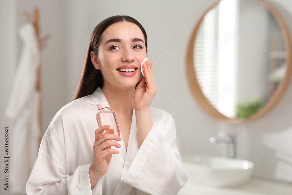 Beautiful woman removing makeup with cotton pad indoors Beautiful woman removing makeup with cotton pad indoors
