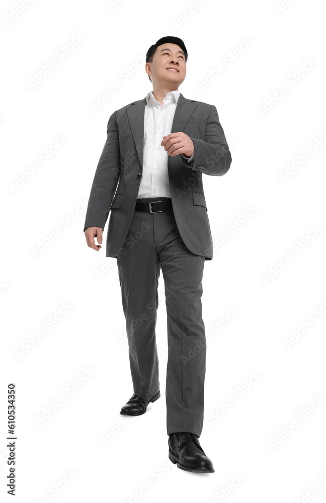 Businessman in suit walking on white background, low angle view Businessman in suit walking on white background, low angle view
