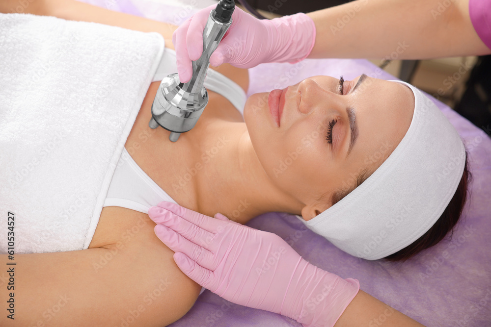 Naklejka premium Young woman undergoing cosmetic procedure in beauty salon. Microcurrent therapy