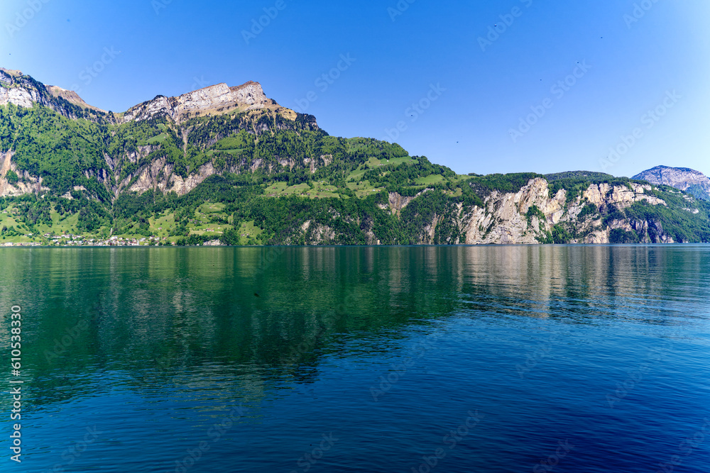 View of Lake Uri with beautiful mountain panorama and village Bauen on a sunny spring day. Photo taken May 22nd, 2023, Sisikon, Switzerland.