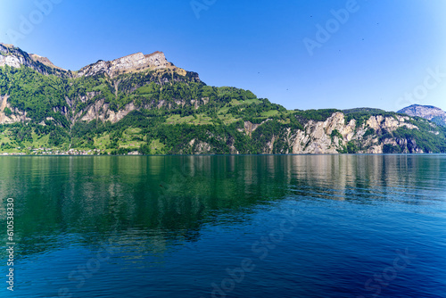 Fototapeta Naklejka Na Ścianę i Meble -  View of Lake Uri with beautiful mountain panorama and village Bauen on a sunny spring day. Photo taken May 22nd, 2023, Sisikon, Switzerland.