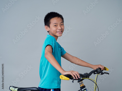 Little boy with bicycle on grey background