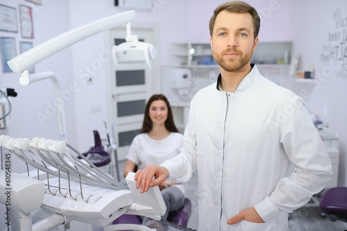 Dental Center. Portrait Of Smiling Middle Eastern Dentist Doctor Posing At Workplace, Handsome Arab Stomatologist Standing In Modern Clinic Interior, Ready For Check Up With Patient
