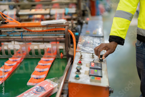 Close-up of hands of african male engineer as a mechanic Hand turning electronic circuit switch by hand steel and plastic production In the business industry, wear a vest.