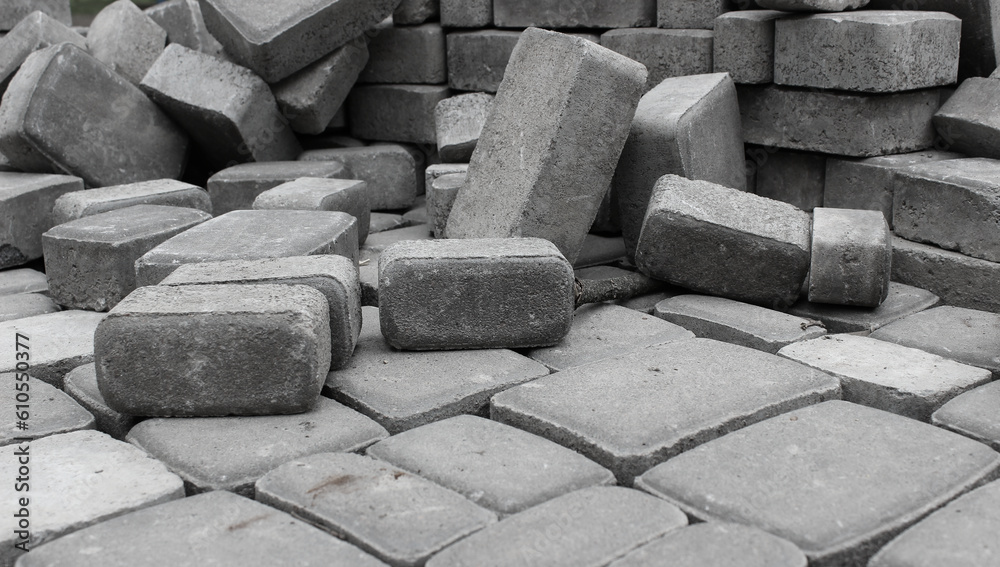 Pavement tiles laid out on a flat surface in front of a pile of similar tiles low point of view Pavement tiles laid out on a flat surface in front of a pile of similar tiles low point of view