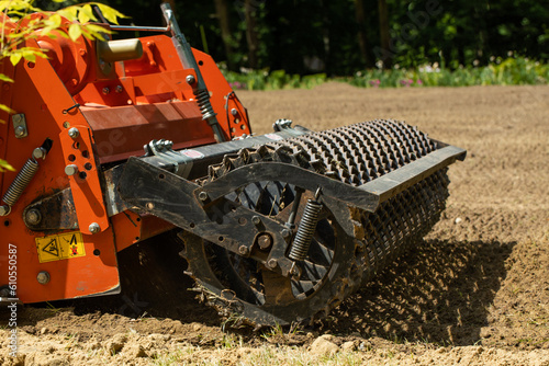 Tractor cultivating the soil with a rotary tiller on the farm. photo