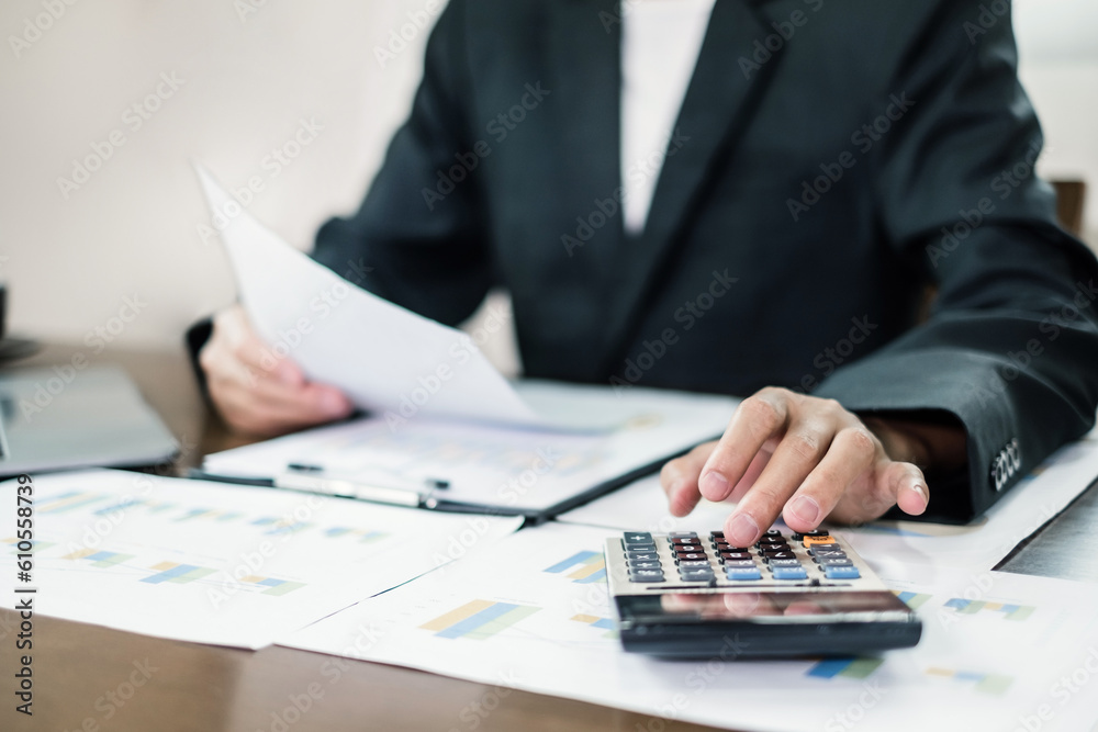 The businessman hand sits at their desks and calculates financial graphs showing the results of their investments planning the process of successful business growth The businessman hand sits at their desks and calculates financial graphs showing the results of their investments planning the process of successful business growth