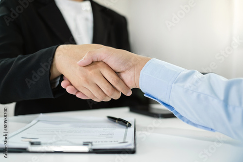 Friendly businessmen and executives shake hands after successful agreement with employment contracts, recruitment, and employment concepts