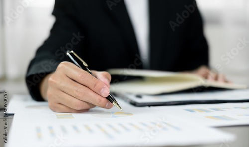 The businessman hand sits at their desks and calculates financial graphs showing the results of their investments planning the process of successful business growth