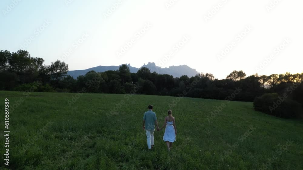 Couple in love walking through the countryside during sunset. Romantic walk in idyllic landscape. Valentine's Day on February 14. Couple in love walking through the countryside during sunset. Romantic walk in idyllic landscape. Valentine's Day on February 14.