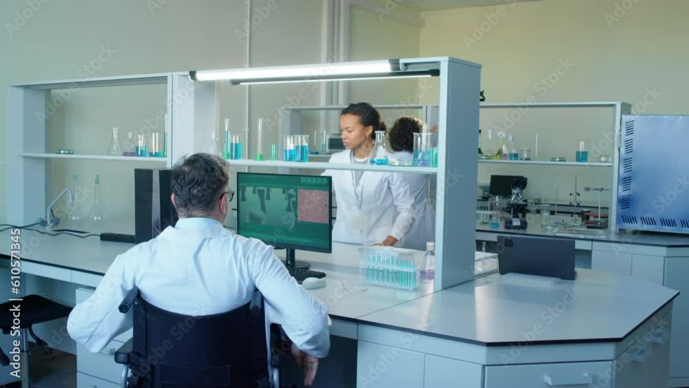 Timelapse of diverse team of scientists working with flasks and computer in laboratory at daytime